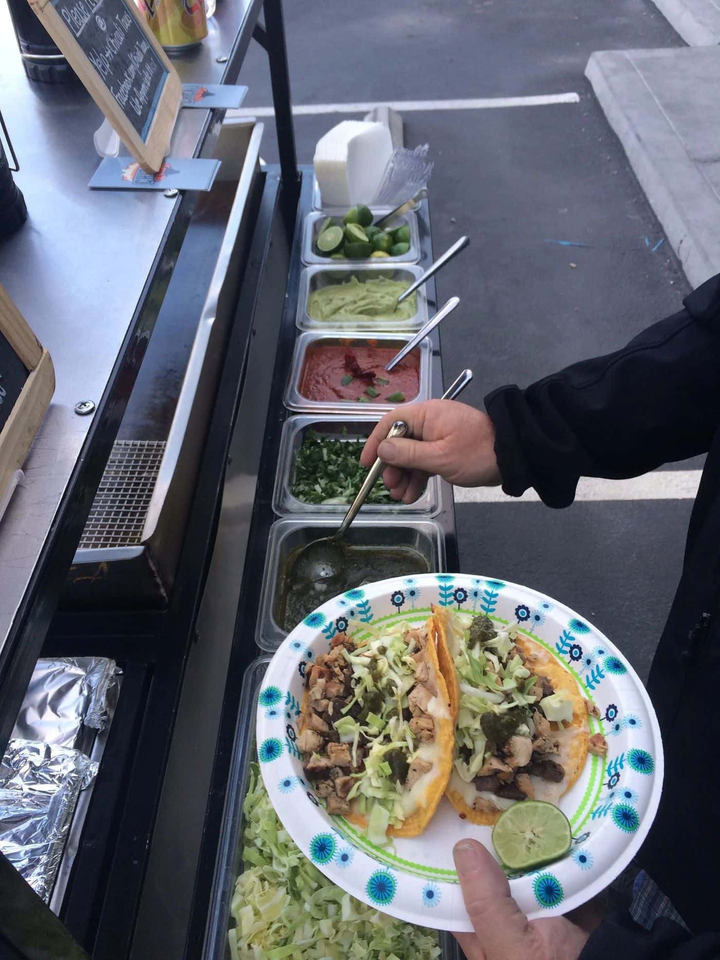 Guest building a taco at the Chicali Tacos toppings bar during a Las Vegas Strip event