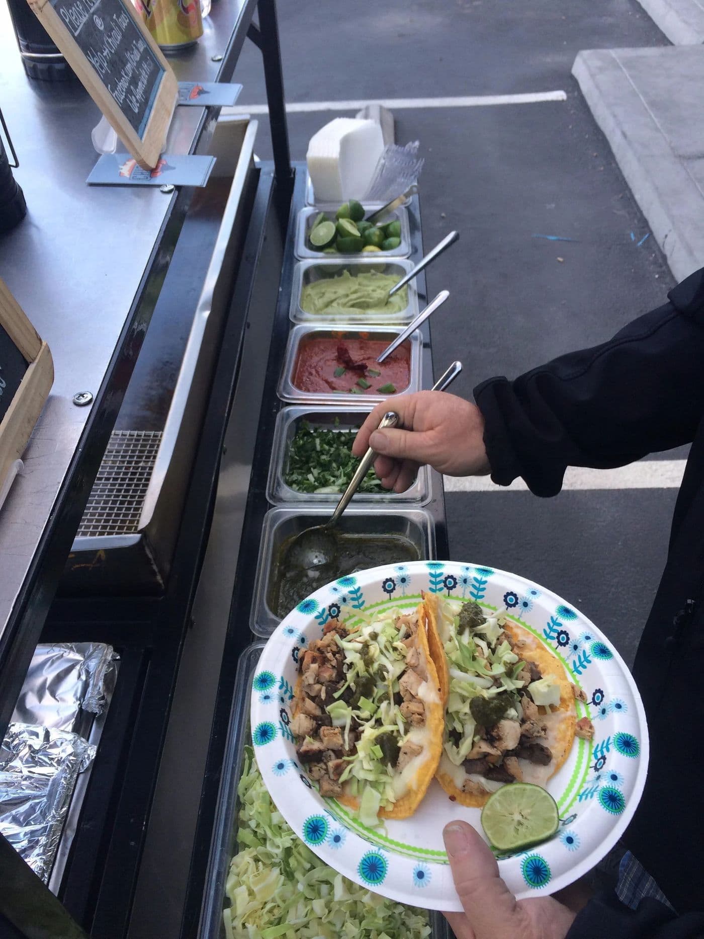 Guest building a taco at the Chicali Tacos toppings bar during a Las Vegas Strip event